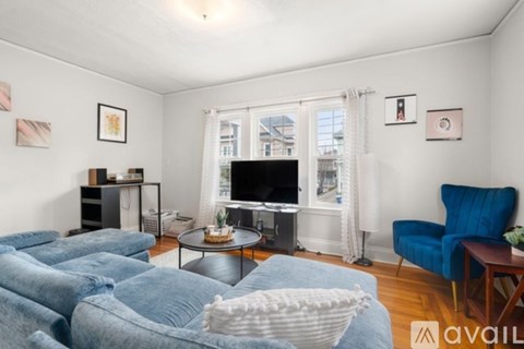 A living room with a blue sofa and a television.