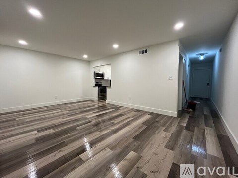 A room with wooden flooring and a sliding glass door.