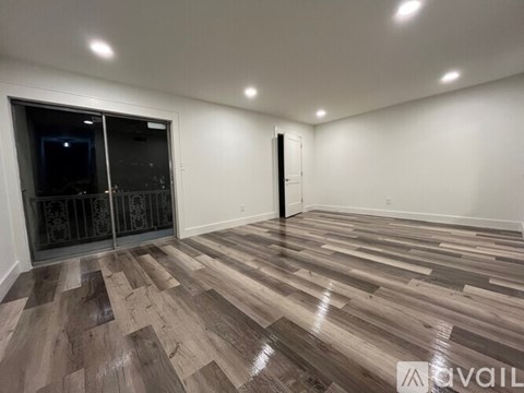 A room with wooden flooring and a white wall.