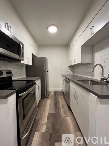 A kitchen with a stove, microwave, and refrigerator.