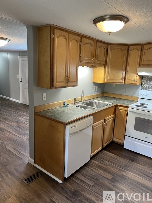 A kitchen with wooden cabinets and a white dishwasher.