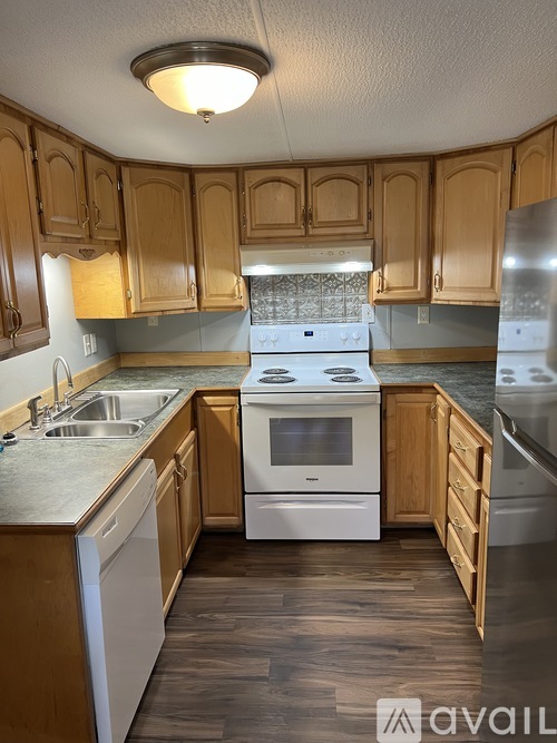A kitchen with wooden cabinets and a white stove top oven.