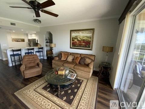 A living room with a brown chair and a painting on the wall.