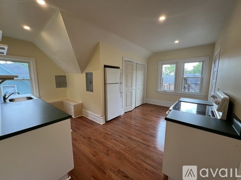 A kitchen with wooden floors and white cabinets.
