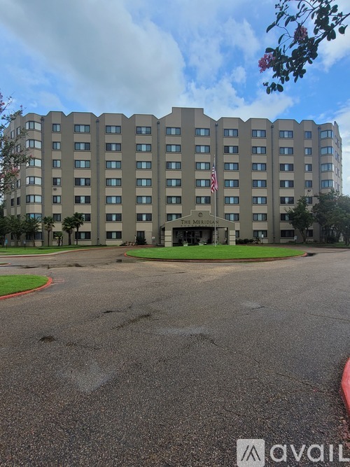 A large building with a flag on it and the word "AVAILABLE" written on the ground in front of it.
