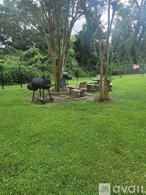 A backyard with a grill and picnic table.