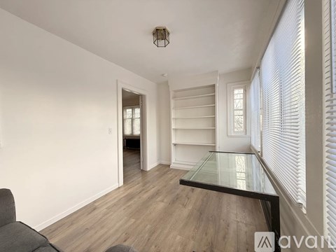 A living room with a grey couch and a glass table.