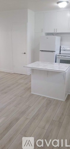 A kitchen with white cabinets and a white fridge.