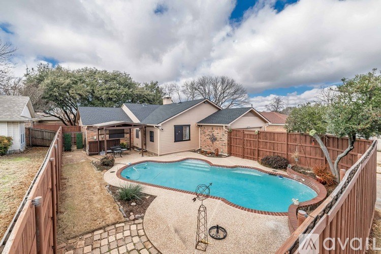 A backyard with a pool and a fence.