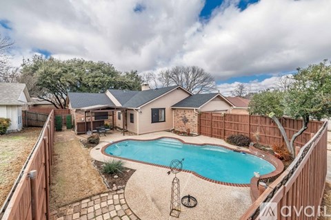 A backyard with a pool and a fence.