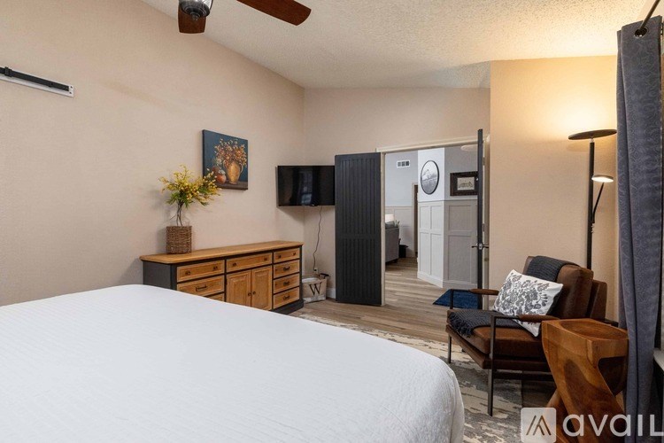 A bedroom with a bed, dresser, and chair.