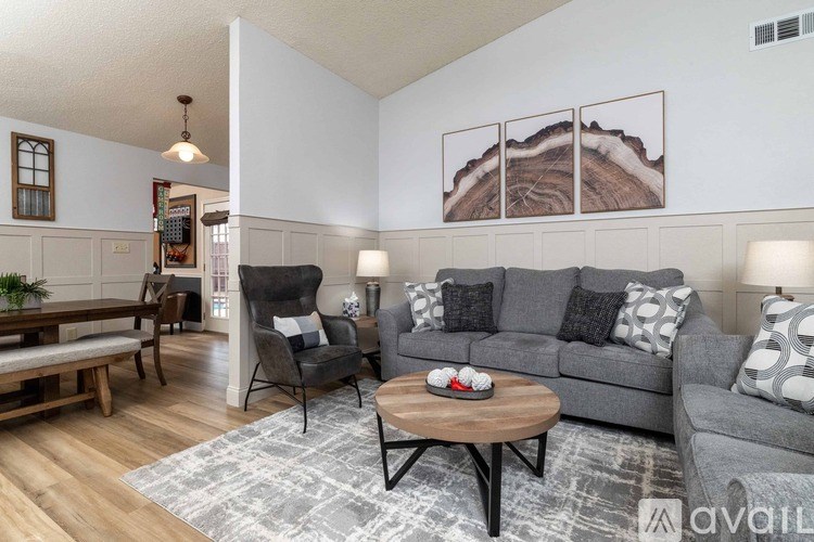 A living room with a grey couch, a wooden coffee table, and a wooden bench.