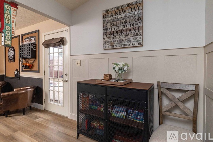 A room with a quote on the wall and a bookshelf filled with books.