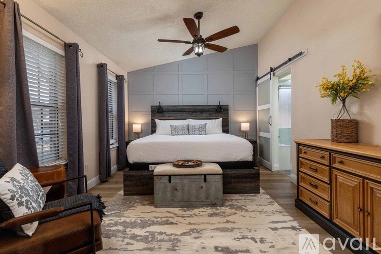 A bedroom with a large bed and a ceiling fan.