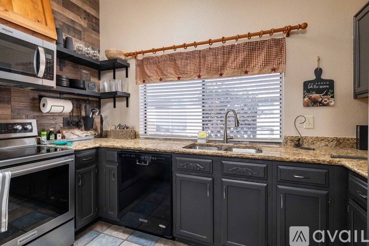A kitchen with black cabinets and a wooden backsplash.