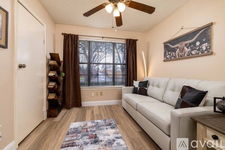 A living room with a white couch and a ceiling fan.