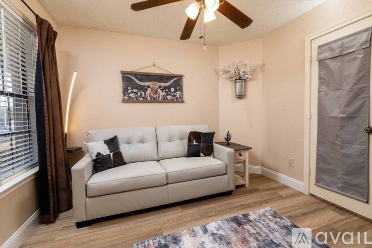 A living room with a white couch and a ceiling fan.