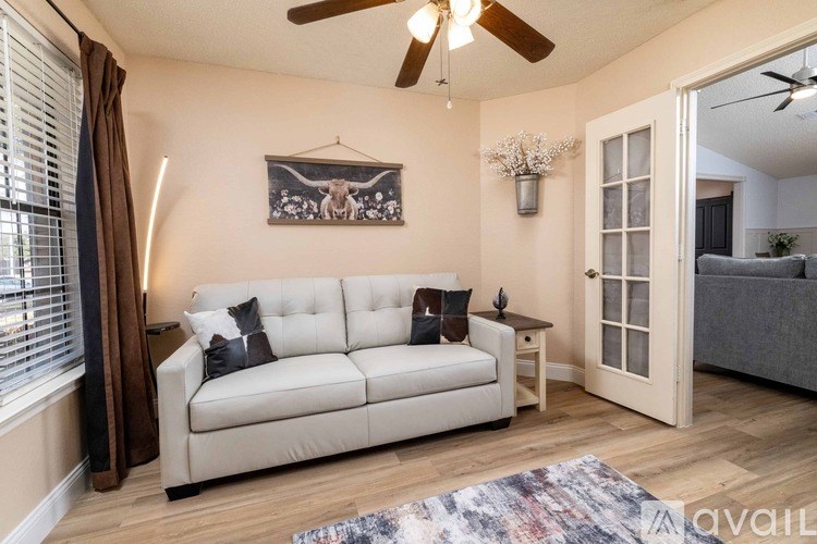 A living room with a white couch and a ceiling fan.
