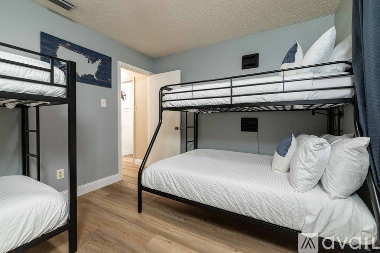 Two bunk beds in a room with a door in the background.