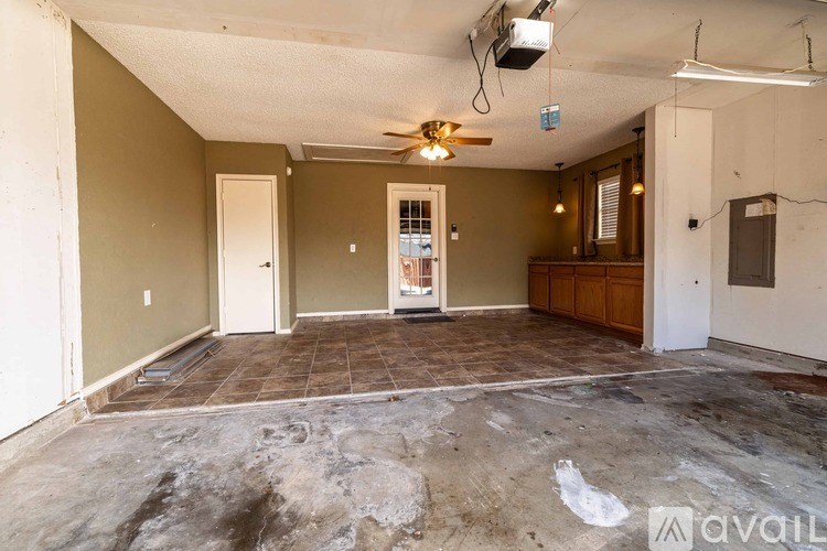 A room with a ceiling fan and a door leading to another room.