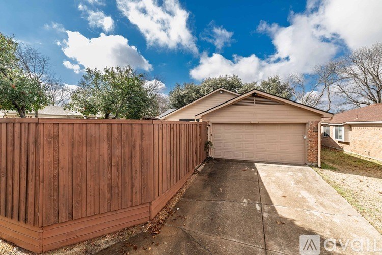 A house with a brown fence and a garage door.