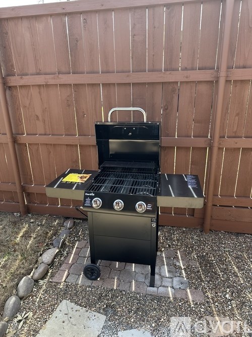 A charcoal grill is on a patio.