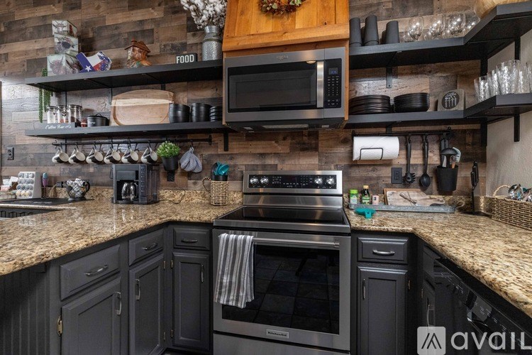 A kitchen with a black oven and a wooden cabinet.