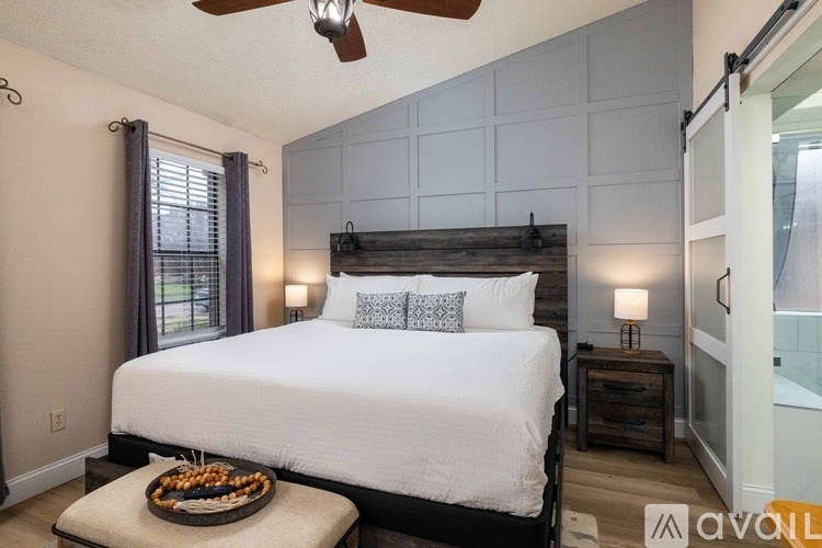 A bedroom with a large bed and a tray of food on the bedside table.