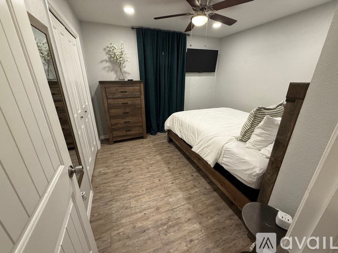 A bedroom with a bed, dresser, and mirror.