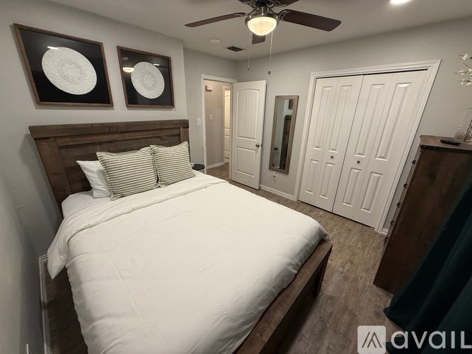 A bedroom with a large bed and two wall art pieces.