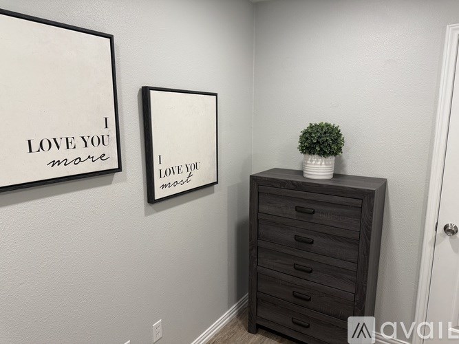 Two framed pictures on a wall saying I love you.