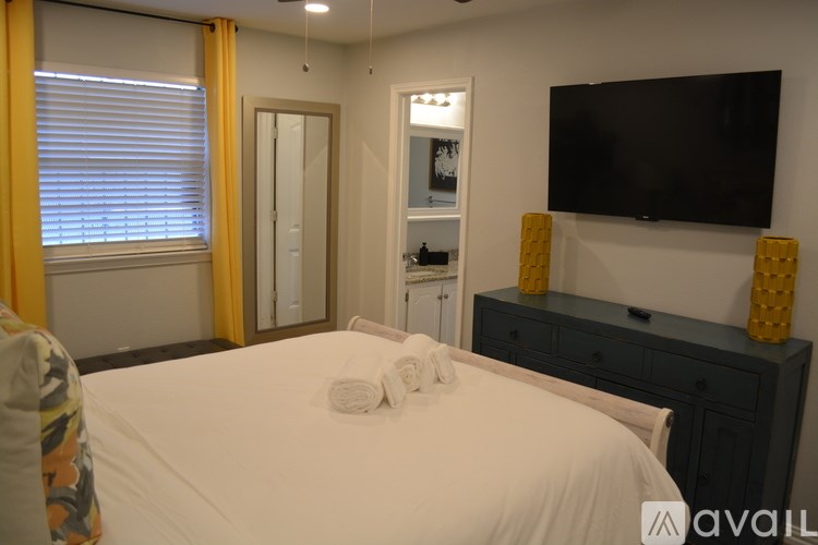 A bedroom with a bed, a dresser, and a television.