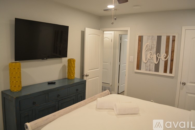A bedroom with a bed, dresser, and television.