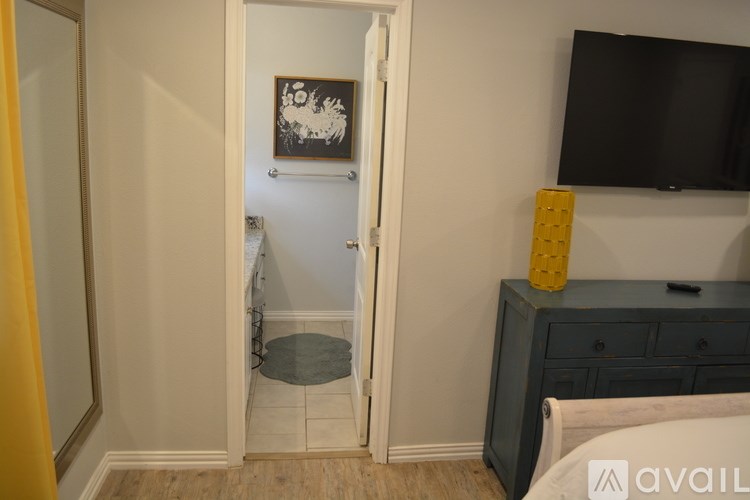 A room with a bed, a dresser, and a painting on the wall.