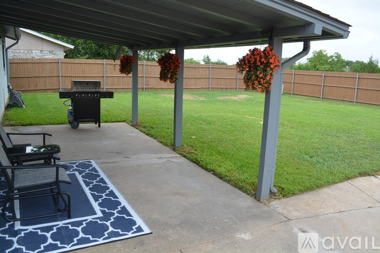 A patio with a table and chairs under a roof.