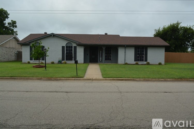 A house with a grey roof and a white exterior is shown.