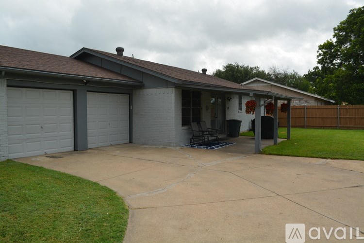A house with a grey garage door and a brown roof.