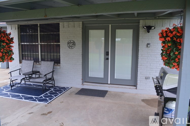 A patio with a table and chairs and a wall with a flower planter.