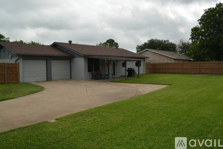 A house with a brown roof and a driveway in front.