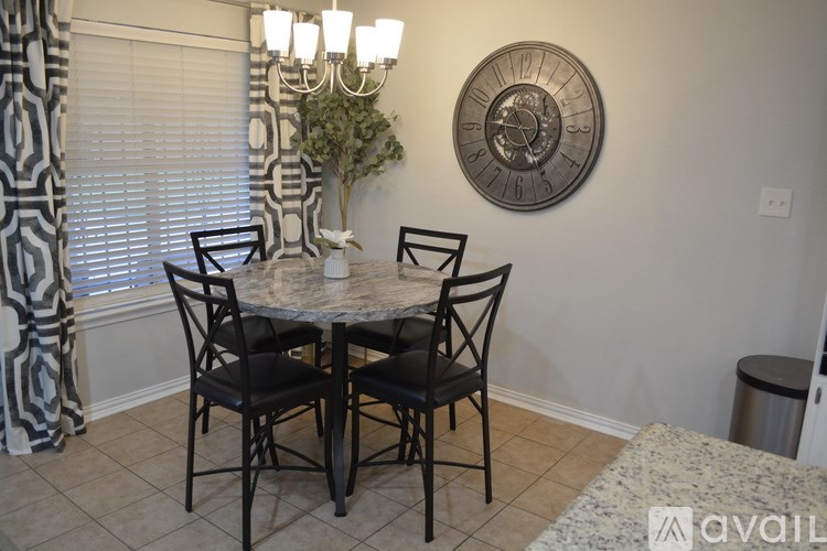 A dining room with a table and chairs.