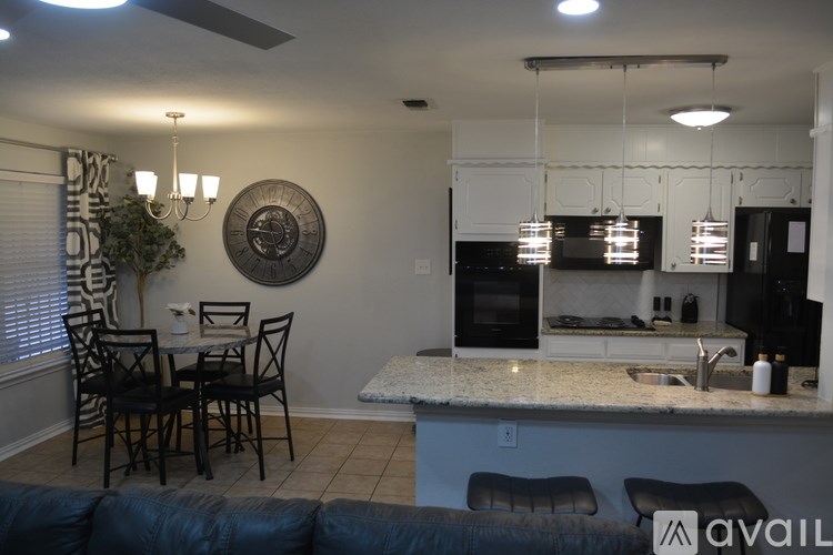 A kitchen with a black fridge and a white countertop.