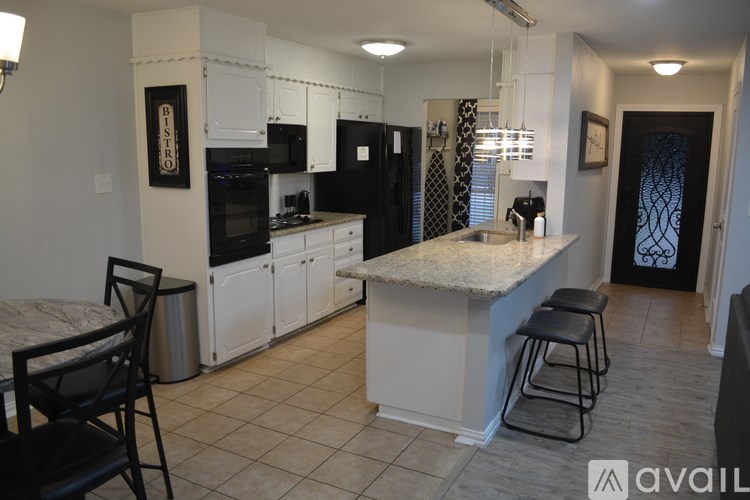 A kitchen with black and white appliances and cabinets.