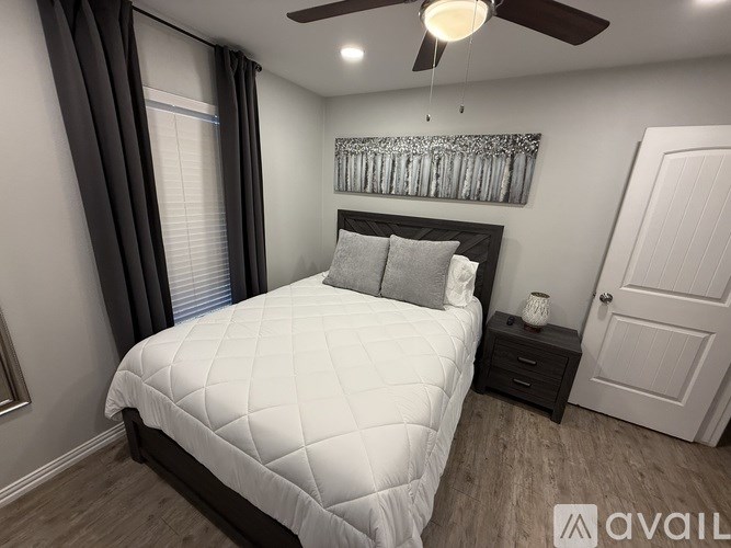 A bedroom with a large bed and a ceiling fan.