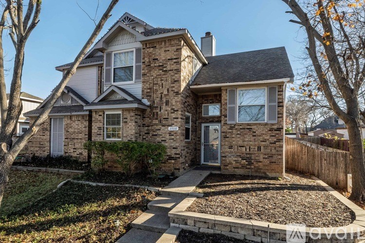 A house with a stone facade and a grey roof.