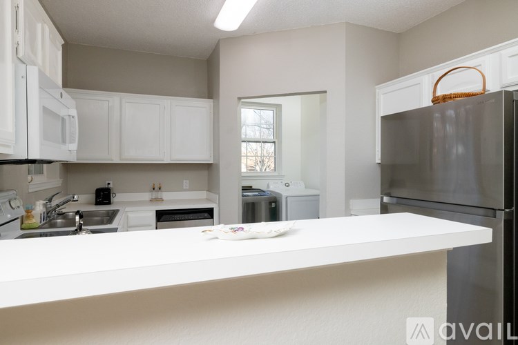 A kitchen with white cabinets and a white countertop.
