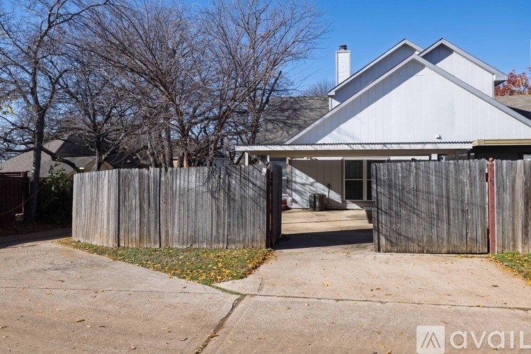 A house with a grey roof and a wooden fence.