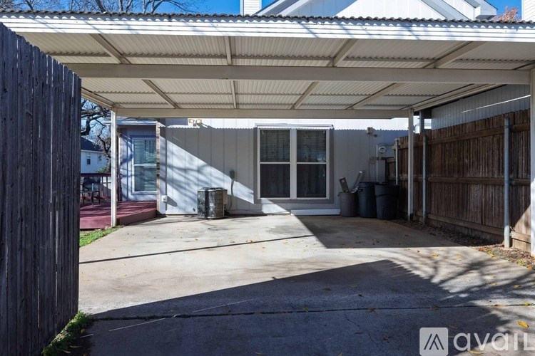 A covered patio area with a concrete floor and a white awning.