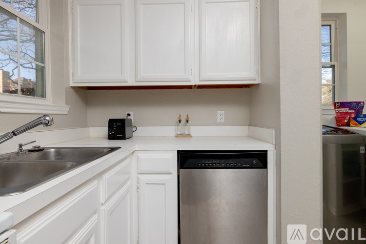 A kitchen with white cabinets and a stainless steel dishwasher.