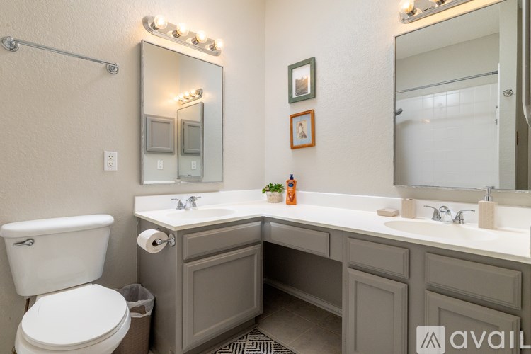 A bathroom with a white toilet, a sink with a mirror above it, and a shower with a glass door.