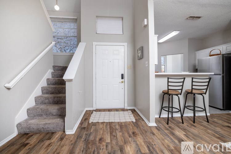 A kitchen area with a refrigerator, two chairs and a counter.